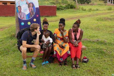 Dansk lærerstuderende i Uganda snakker med kvinder