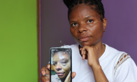 Ugandisk kvinde viser forslået billede af sig selv på telefonen